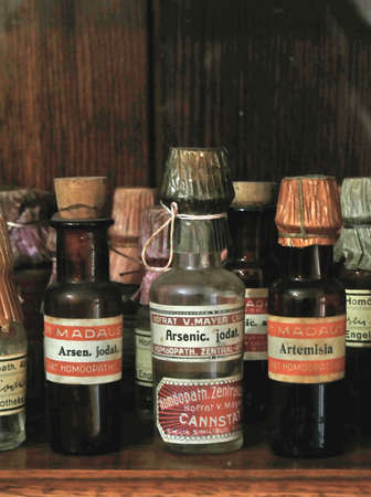 Old arsenic bottle surrounded by other medicine bottles.の写真素材