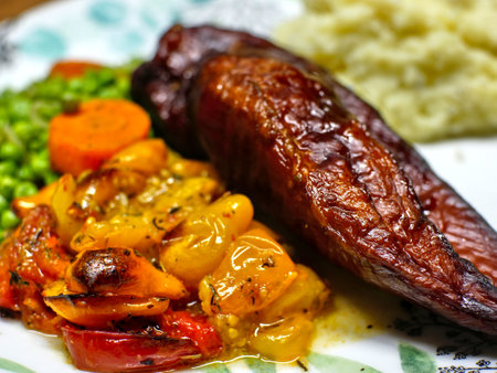 Slighlty blurred close up of a smoked chicken breast and candied tomatoes.の写真素材