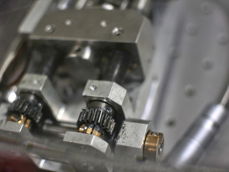 Slightly blurred aluminium mechanical part with holes, gears, wheel. For engineering or mechanical...