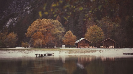 Two mountain cottages by the lake sorounded with peaceful autumn colored landscapeの写真素材