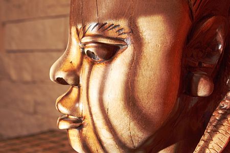 Ancient wooden sculpture from Africa on a sunlight. の写真素材