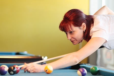 The young woman playing billiards