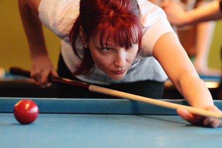 The young woman playing billiardsの写真素材