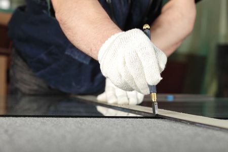 The worker, cutting a mirror,focus on a handの写真素材