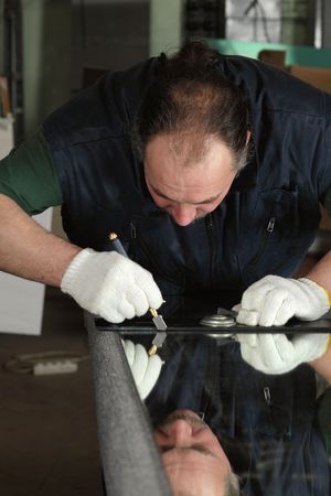 The worker, cutting a mirror,focus on a handの写真素材