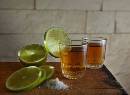 gold tequila and lime on a old wooden tableの写真素材