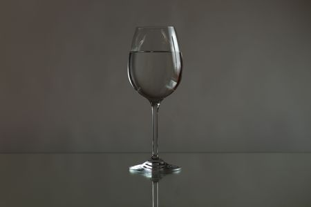 glass with water on a mirror tablrの写真素材