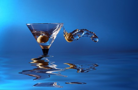 wineglass with martini and green olivesの写真素材