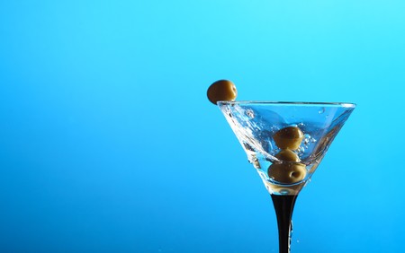 glass with martini and green olivesの写真素材