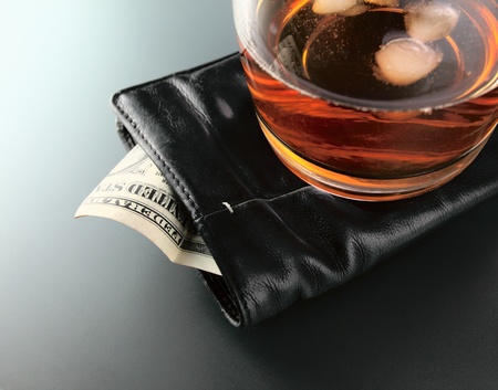 Whisky and money in black purse.の写真素材