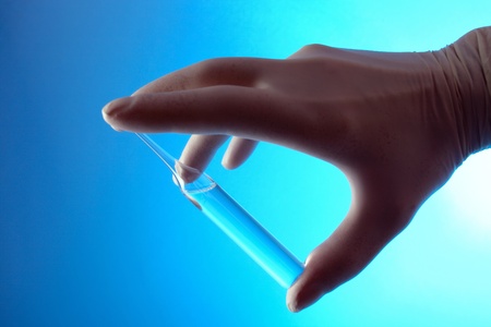 Hand in rubber glove with ampoule .の写真素材