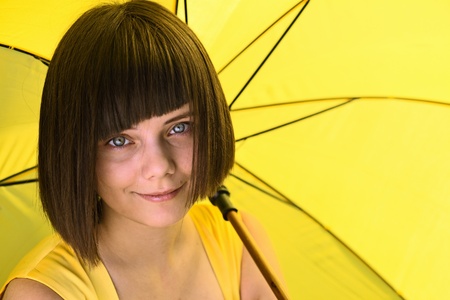 Young  girl with yellow umbrella.の写真素材