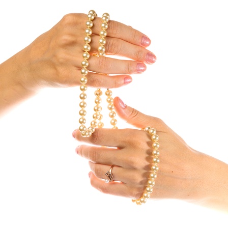 Female hands with a pearl necklace on a white background.の写真素材