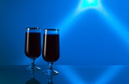 Cherry brandy on a glass table, a background is shined by the blue filter.の写真素材