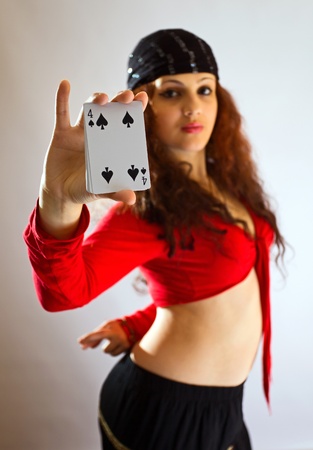 The young beautiful gipsy girl predicts the future on cards.Focus on a card.の写真素材