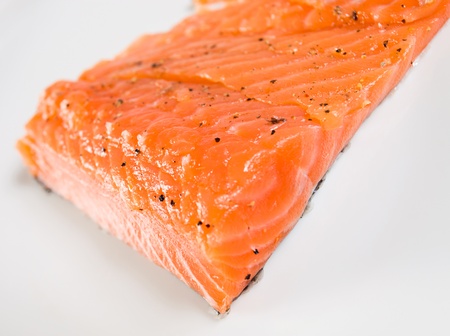 salmon steak with spices on a white plate.の写真素材