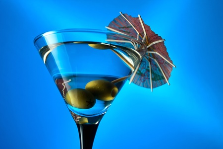 wineglass with martini and green olives on a blue background.の写真素材