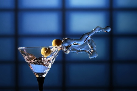 glass with martini and green olives on a dark backgroundの写真素材