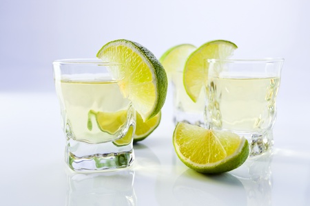 gold tequila with lime on a white reflective background.の写真素材