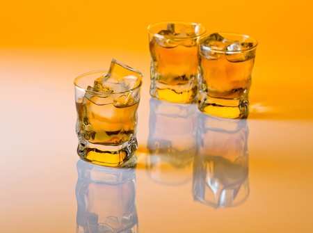 whisky with ice on a white reflective background,focus on a foreground.の写真素材