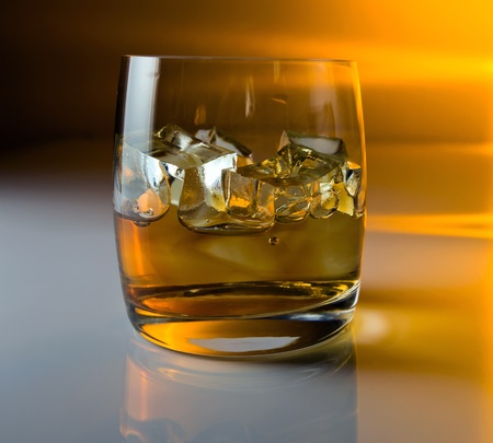 whisky with ice on a white reflective background.の写真素材