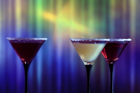 Three glasses with cocktail on a dark background.の写真素材