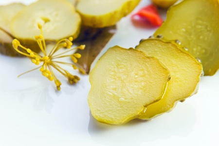 preserved  cucumbers on a white plate . Macro shot , focus on a center.の写真素材