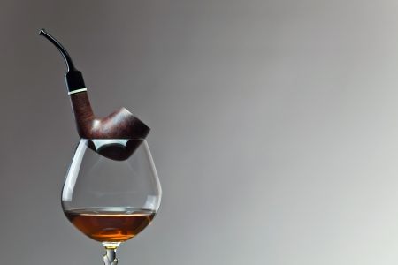 cognac and pipe on a grey background.の写真素材
