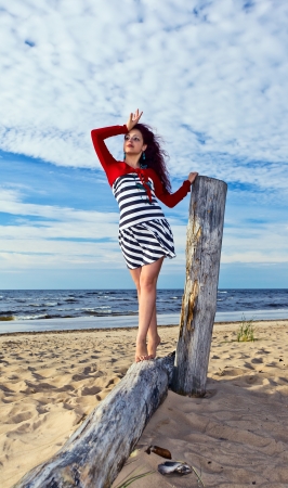 The young woman in striped dress on a beach.の写真素材