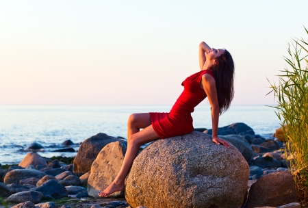 beautiful girl on seacoast before a sunsetの写真素材