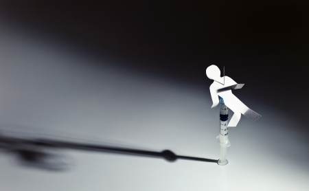 The conceptual image on a theme of narcotic dependence, a white reflective background.の写真素材