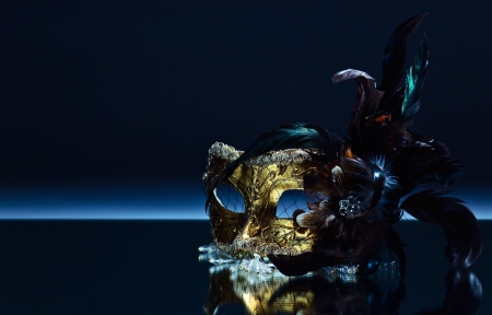 The Venetian mask with feather on a mirror tableの写真素材