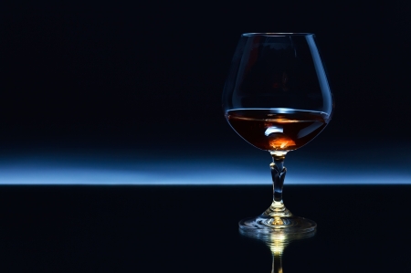 snifter with brandy on a dark background.の写真素材