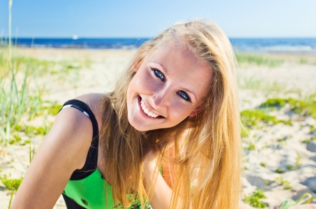 happy woman in green sundress on a beach.の写真素材
