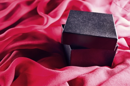 black gift box on a red textileの写真素材