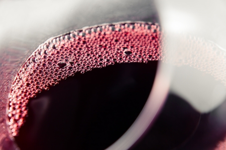 Red wine in wineglass , focus on a foamの写真素材