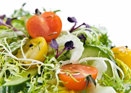 fresh salad with tomatoes ,cucumber and greens, isolated on whiteの写真素材