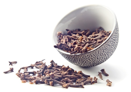 cloves  in a small ceramic cup on a white background