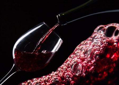 bottle and glass with red wine on a black backgroundの写真素材