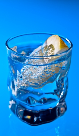 alcohol drink with lemon on a glass tableの写真素材