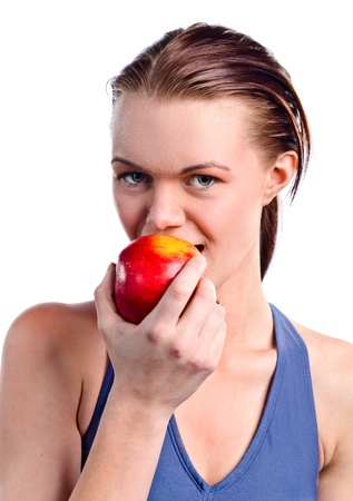 young beautiful girl in sportswear with apple, isolated on whiteの写真素材