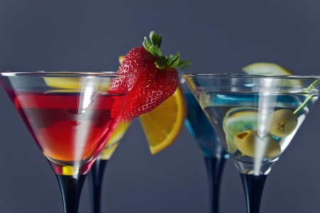 Different cocktails or longdrinks garnished with fruitsの写真素材