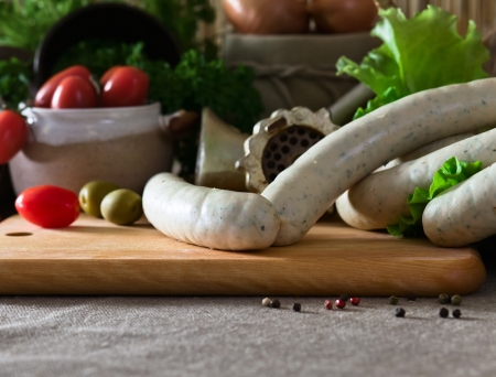 Bavarian sausage and vegetables on a kitchen tableの写真素材