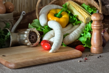 Bavarian sausage and vegetables on a kitchen tableの写真素材