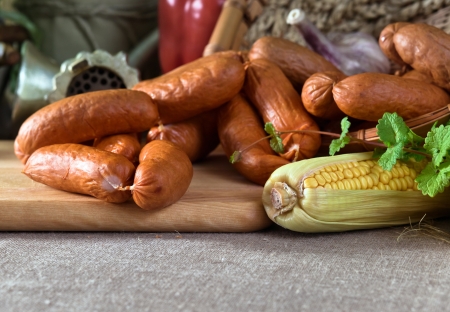 smoked sausage and vegetables on a linen clothの写真素材