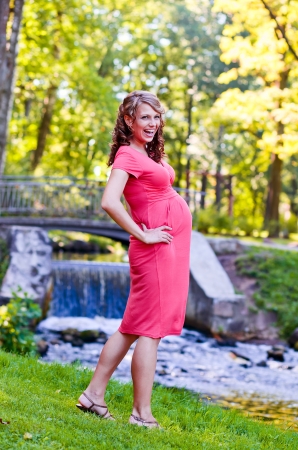 The young pregnant woman on walk in parkの写真素材