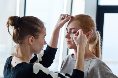 The stylist does a make-up for photosession