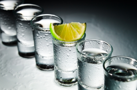 tequila and lime on a damp glass tableの写真素材