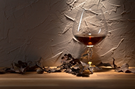 snifter with brandy and dried oak leavesの写真素材
