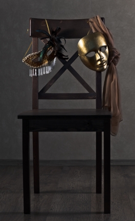  Old gold Venetian masks on a wooden chairの写真素材